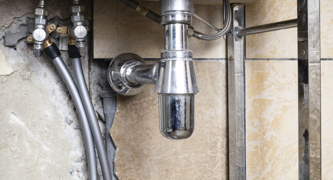 Water Pipes Connected To Valve Of Sink In Bathroom