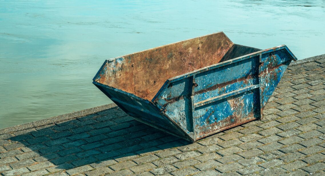 Old Worn Skip Container On Riverbank